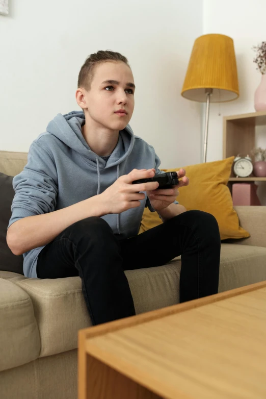 a man sitting on a couch playing a video game, featured on reddit, realism, 1 7 - year - old boy thin face, profile picture 1024px, 💣 💥💣 💥, skydsgaard