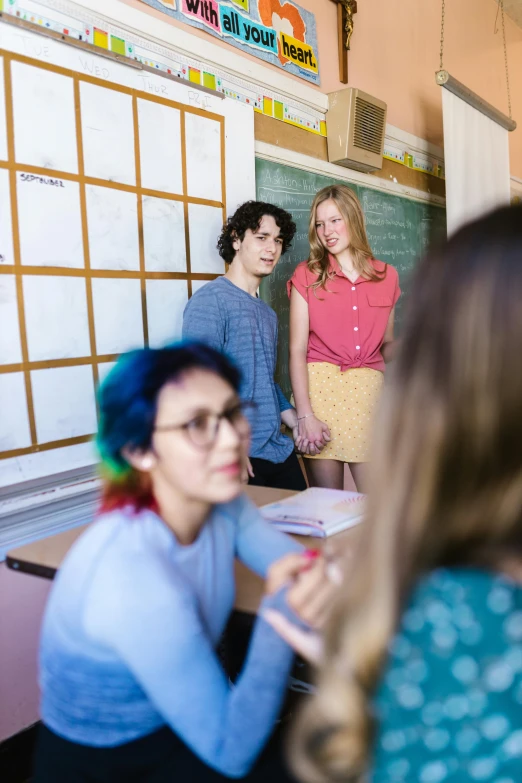 a group of people standing in front of a whiteboard, trending on unsplash, heidelberg school, transgender, teenage girl, in a school classroom, colorful scene