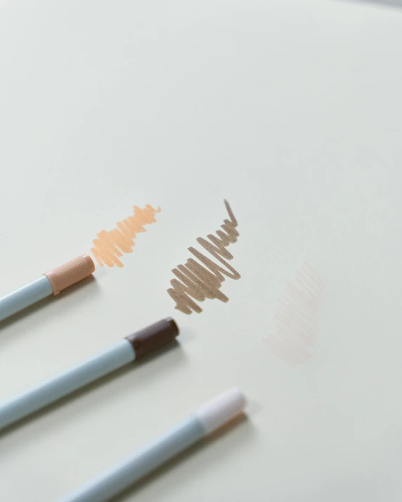 a couple of pencils sitting on top of a table, pastel makeup, minimal outlines, detailed product image, three colors