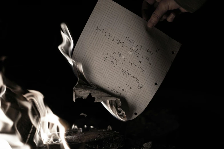 a person holding a piece of paper over a fire, math equations, dark and intricate photograph, thumbnail, photoshoot