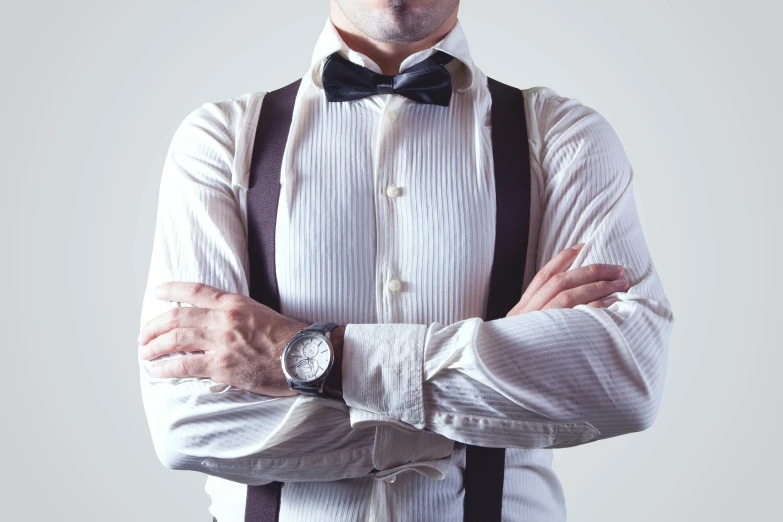 a man wearing a bow tie and suspenders, trending on pexels, folded arms, wearing a fancy dress, wearing a light shirt, wearing jewellery