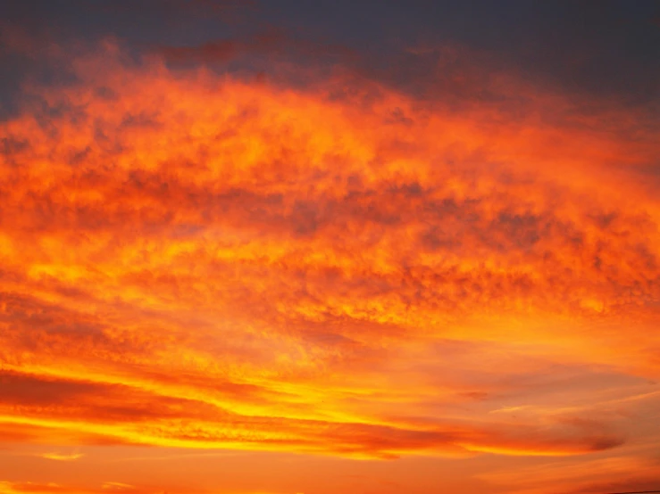 a large body of water with a sunset in the background, by Alison Watt, pexels contest winner, romanticism, red cumulonimbus clouds, vibrant orange, a close-up, major arcana sky