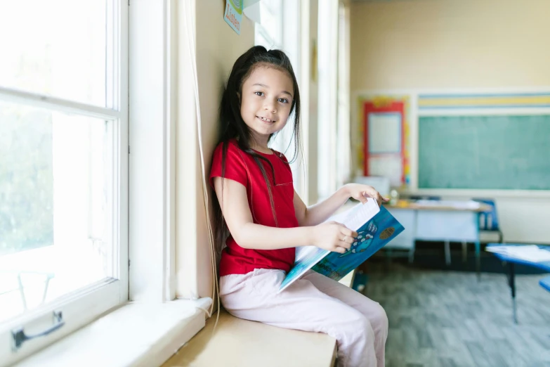 a little girl sitting on a window sill reading a book, a picture, by Nicolette Macnamara, pexels contest winner, danube school, standing in class, damien tran, sitting in a waiting room, avatar image