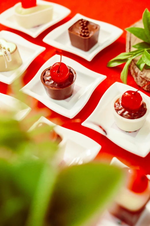 a table topped with different types of desserts, red theme, zoomed in shots, lush green, thumbnail