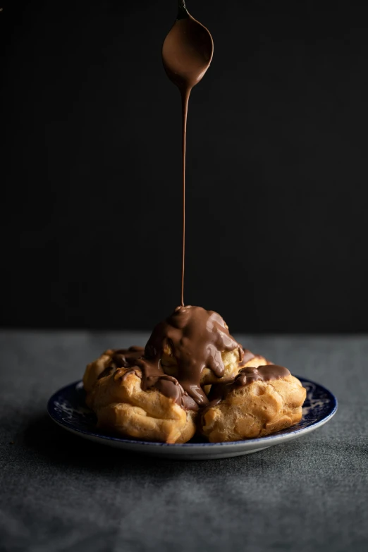 a plate of waffles with chocolate sauce being drizzled over them, a portrait, inspired by Joris van der Haagen, unsplash, baroque, cannonballs, portrait n - 9, bronze, voluminous