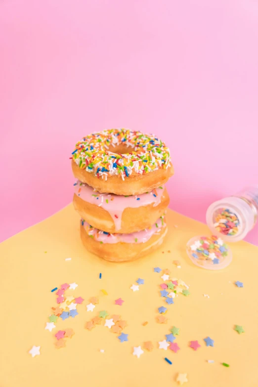 a couple of doughnuts sitting on top of a table, sprinkles, 🍸🍋, profile image, product shot