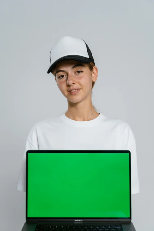 a person holding a laptop with a green screen, by Matthias Stom, white baseball cap, portrait of white teenage girl, subreddit / r / whale, on a gray background