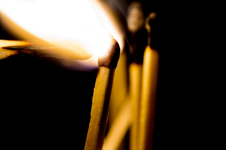 a group of matches sitting on top of each other, a macro photograph, by Thomas Häfner, process art, wall torches, close-up photo, yellow light spell, over-shoulder shot