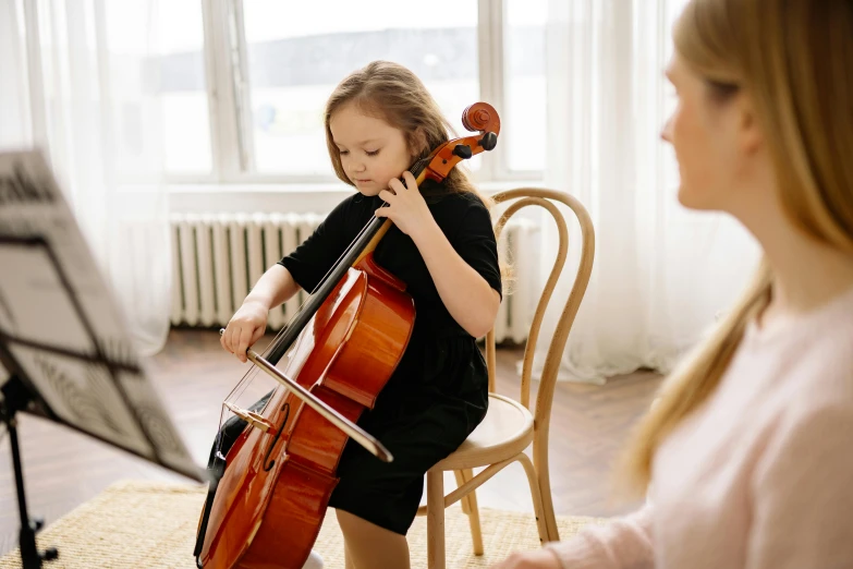 a little girl sitting on a chair playing a cello, pexels contest winner, danube school, thumbnail, abcdefghijklmnopqrstuvwxyz, straya, rectangle