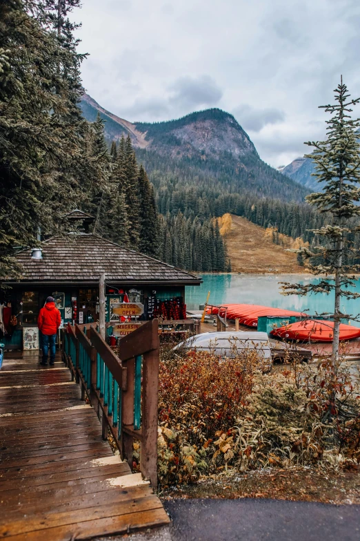 a couple of boats sitting on top of a lake, behind bar deck with bear mugs, banff national park, gazebos, top selection on unsplash