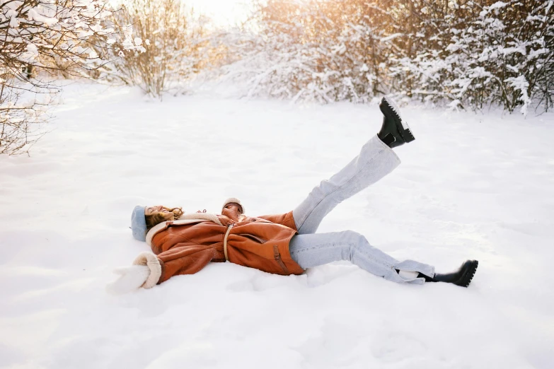 a man laying on his back in the snow, pexels contest winner, cute woman, warm color clothes, avatar image, thumbnail