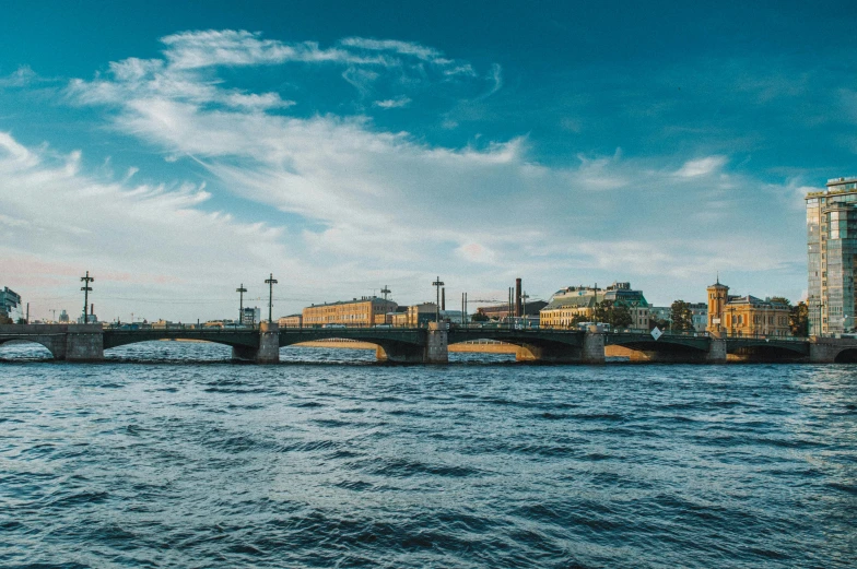 a bridge over a body of water with buildings in the background, a picture, by Julia Pishtar, pexels contest winner, neoclassicism, saint petersburg, sunny sky, youtube thumbnail, wide angle river