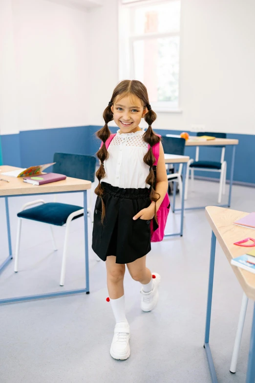a little girl standing in the middle of a classroom, a portrait, trending on pexels, american barbizon school, wearing black shorts, japanese collection product, full - length photo, happy girl