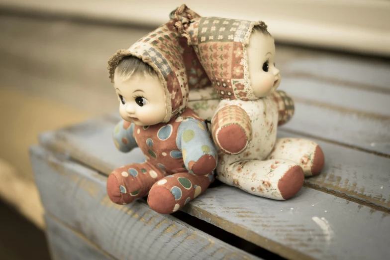 a couple of dolls sitting on top of a wooden bench, by Elsa Bleda, trending on pixabay, kitsch movement, cozy wallpaper, patchwork, vintage closeup photograph, kewpie