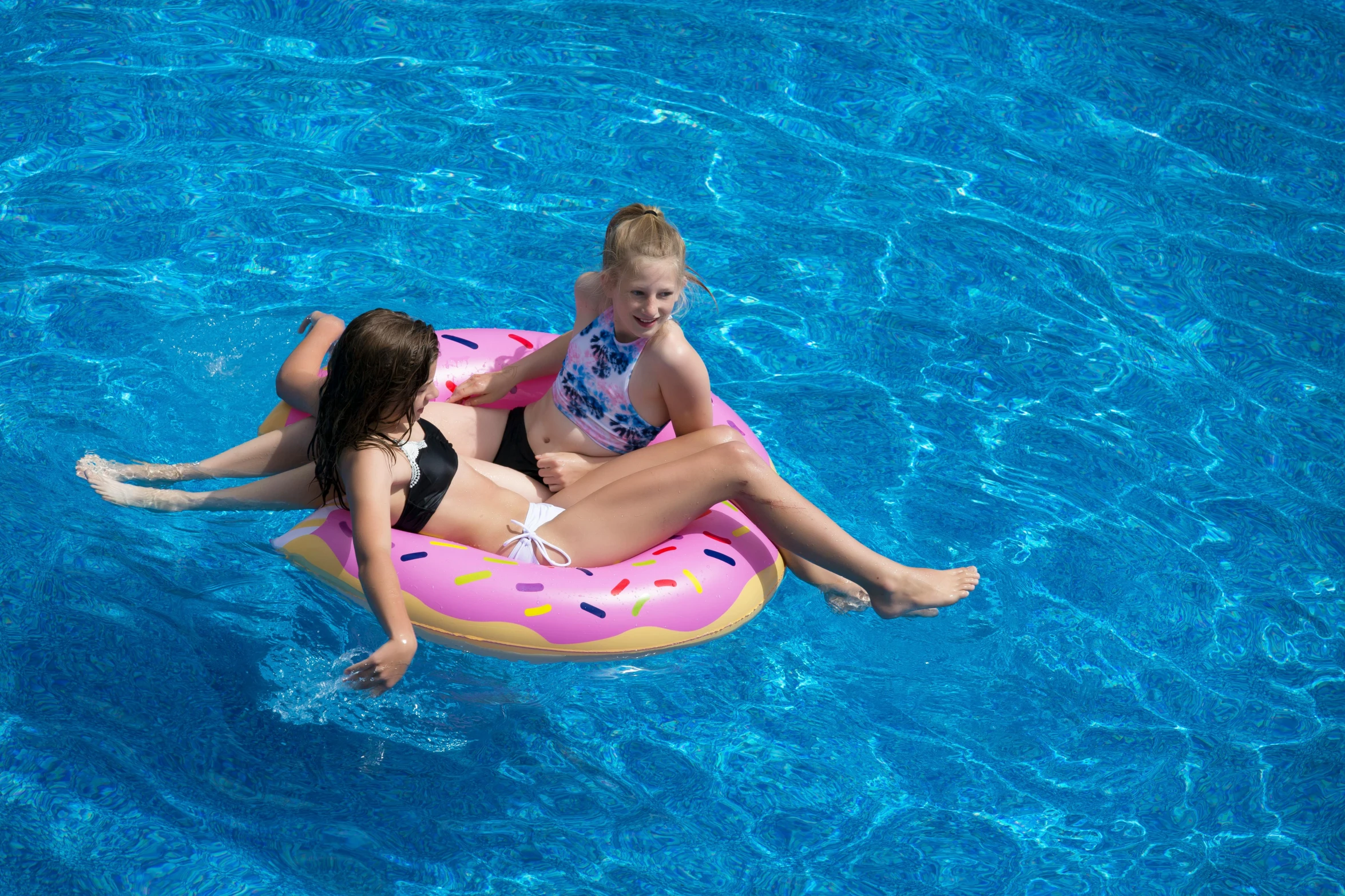 two girls sitting on an inflatable donut in a pool, pexels, on a hot australian day, thumbnail, top down photo, sunny day time