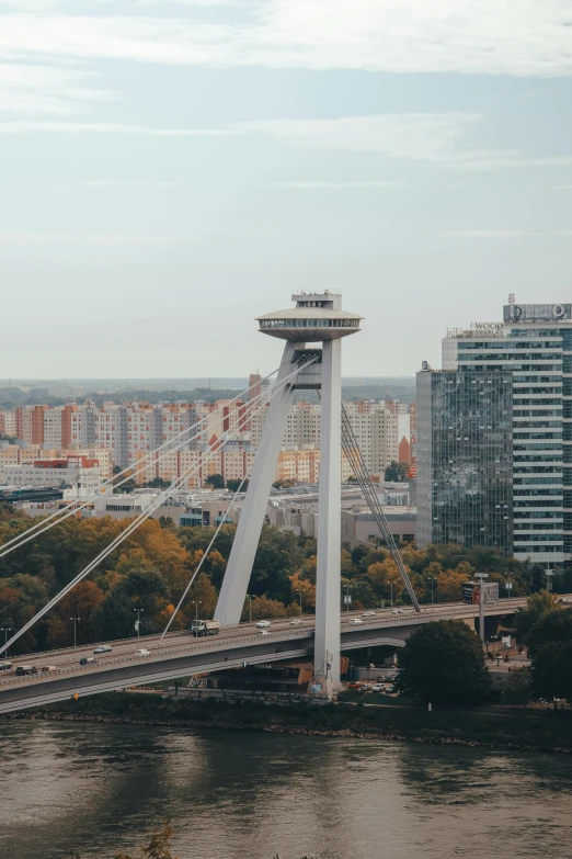 a bridge over a river with a city in the background, by Adam Szentpétery, pexels contest winner, happening, ferris wheel, panorama view, an extreme closeup shot, brutalist buildings tower over