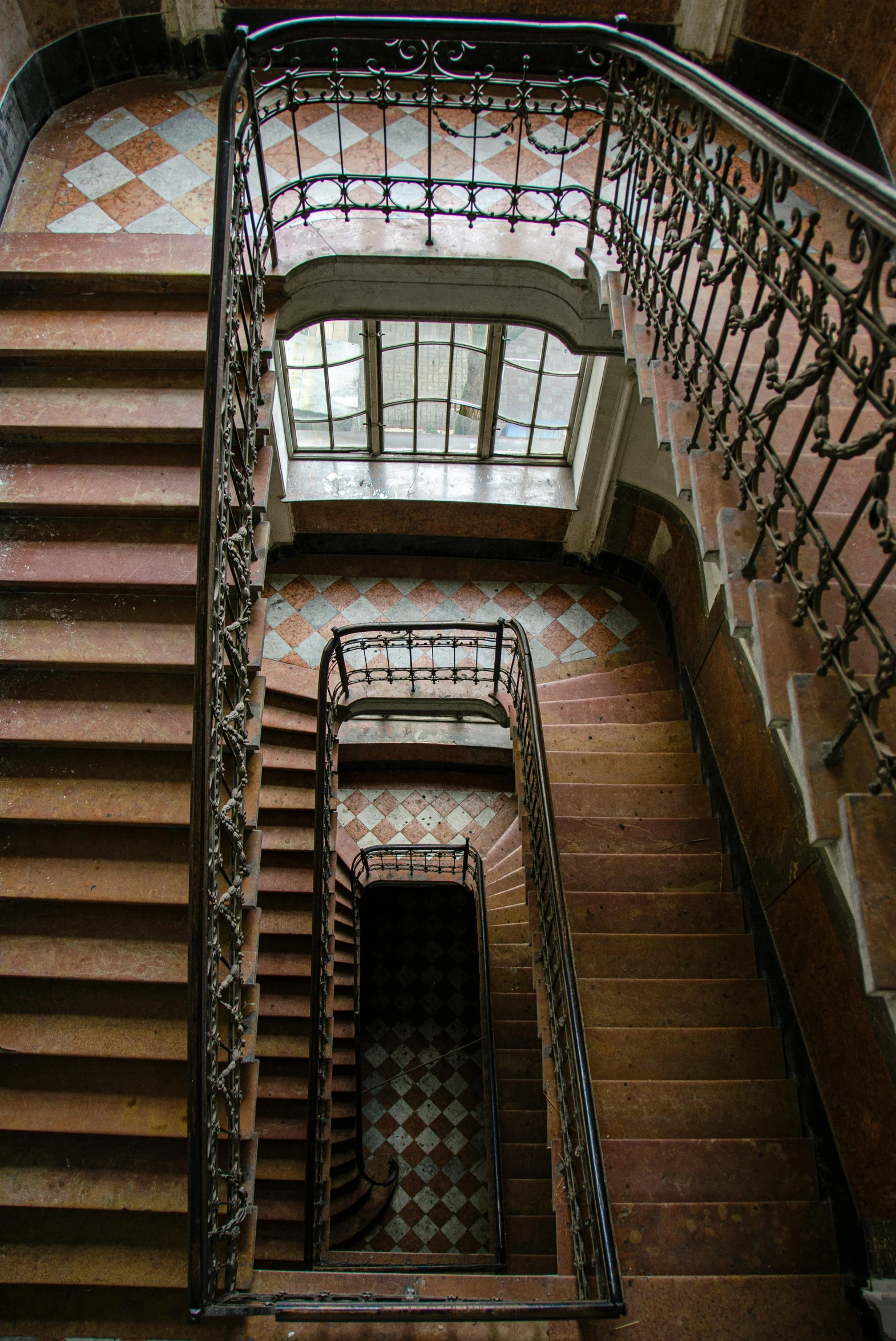 a spiral staircase in a building with a skylight, an album cover, art nouveau, old stone steps, tiles, rust, university