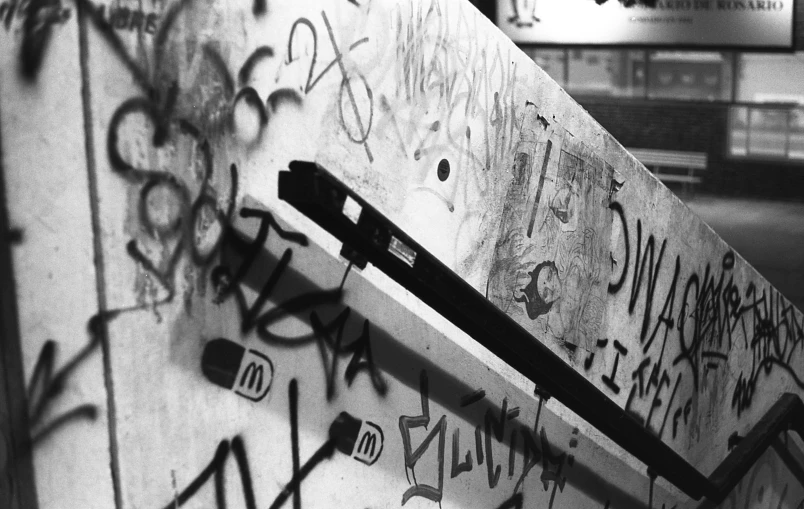 a black and white photo of graffiti on a wall, guillotine, hidden camera photo