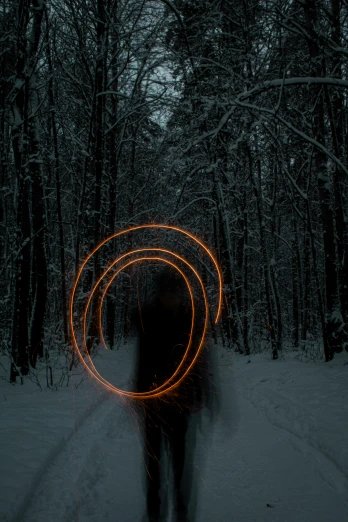 a person standing in the middle of a snow covered forest, electric orange glowing lights, circle forms, black circle, whirling