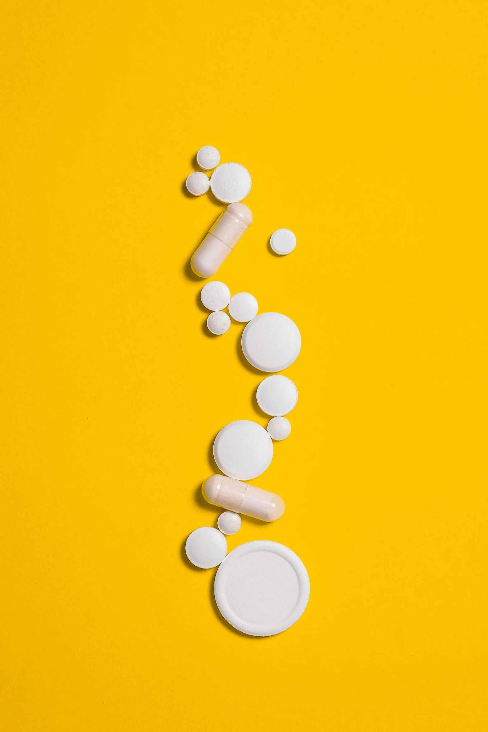 pills on a yellow background, by Chris Rahn, trending on pexels, process art, tall thin, getty images, white colors, question marks