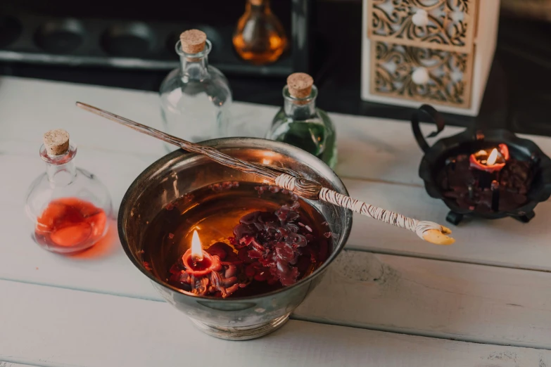 a bowl filled with liquid sitting on top of a table, a still life, trending on pexels, casting a fire spell, dried blood, wands, botanical