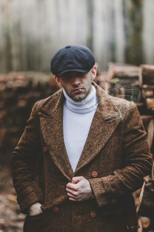 a man standing in front of a pile of logs, a portrait, inspired by Henry Woods, trending on pexels, renaissance, costumes from peaky blinders, wearing a turtleneck and jacket, tweed colour scheme, photo of a model
