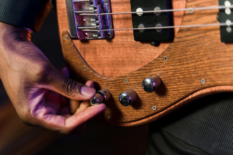 a close up of a person holding a guitar, tactile buttons and lights, bass wood, alembic, octane fender