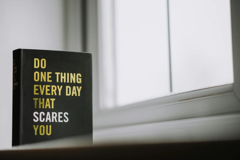 a book sitting on top of a window sill, trending on unsplash, graffiti, whole card, inspirational quote, pc screen image, caring