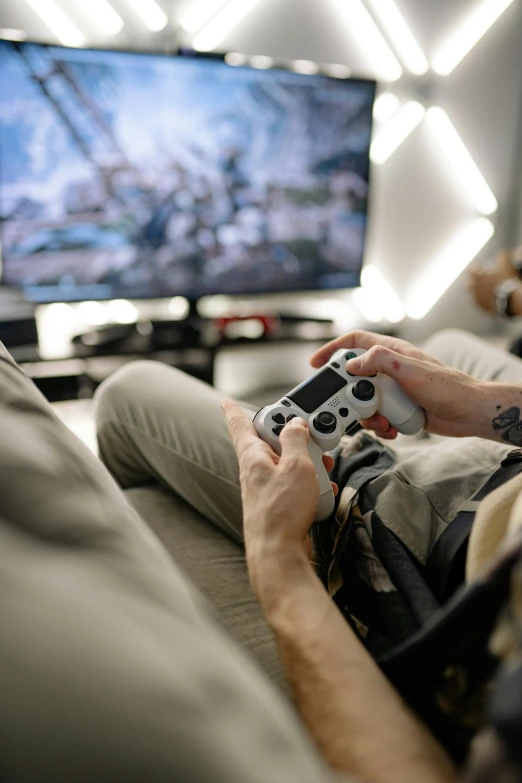 a man sitting on a couch playing a video game, pexels, style game square enix life, on