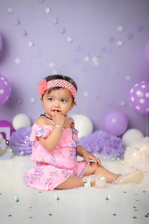 a baby girl sitting in front of a bunch of balloons, a portrait, shutterstock contest winner, purple outfit, bokeh chrome accents, ameera al taweel, studio background