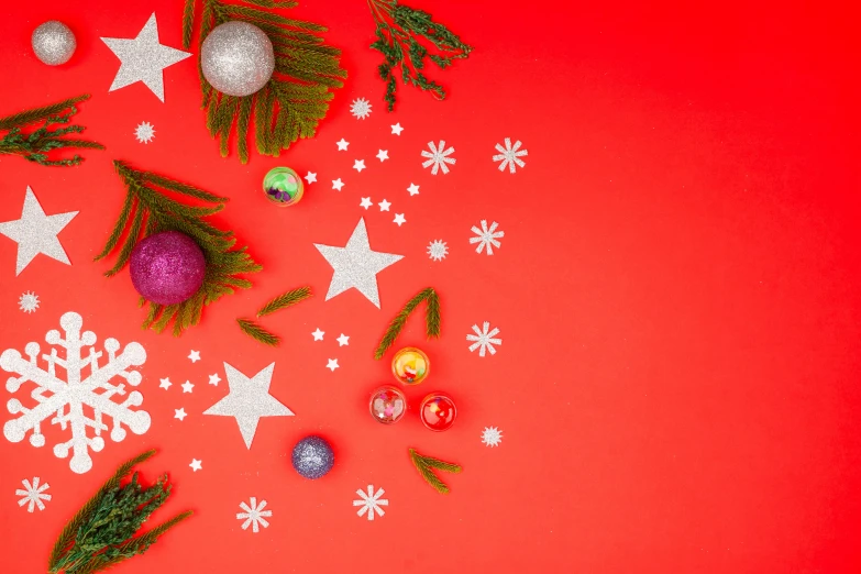 christmas decorations on a red background, by Julia Pishtar, colorful stars, background image, thumbnail, flatlay