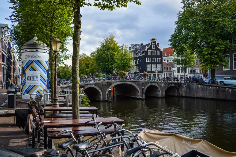 bicycles parked on the side of a river next to a bridge, by Jan Tengnagel, pexels contest winner, dutch houses along a river, drinking, slide show, thumbnail