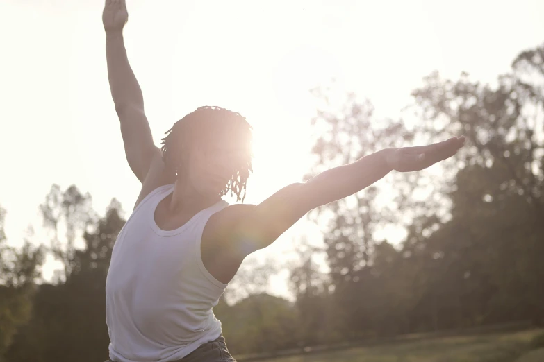 a person jumping in the air with a frisbee, pexels contest winner, yoga pose, sunlight filtering through skin, rodney matthew, with arms up