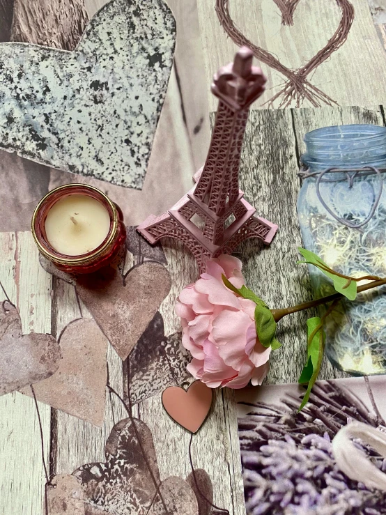 a pink rose sitting on top of a table next to a candle, a picture, variety of shapes and textures, detailed product image, grey, dreamscape in a jar