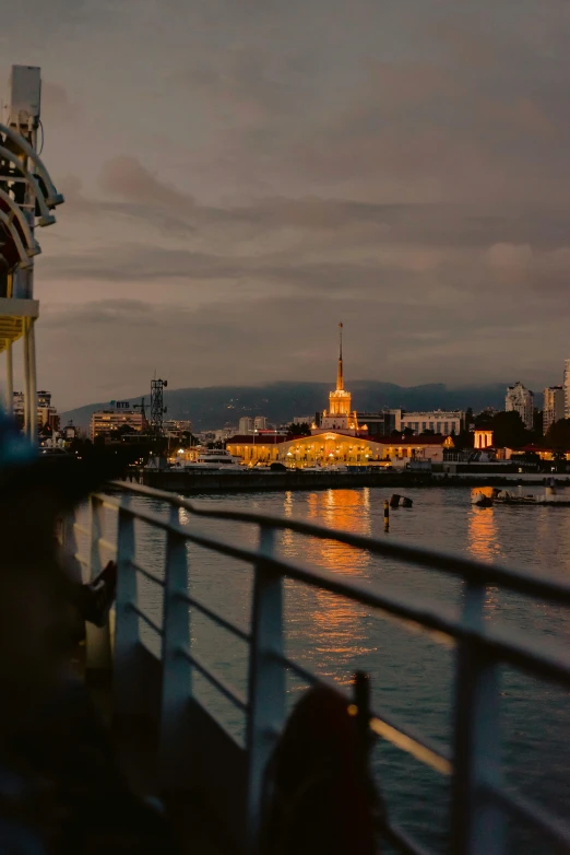 a group of people standing on top of a boat, vista of a city at sunset, beautifully lit buildings, puerto rico, square