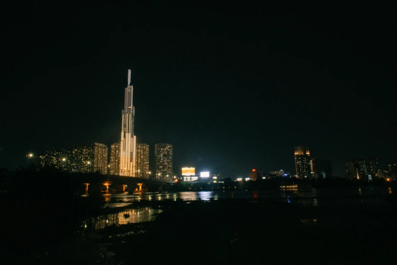 the city skyline is lit up at night, an album cover, pexels contest winner, modernism, photo taken on fujifilm superia, jin kim, high quality photo, building along a river