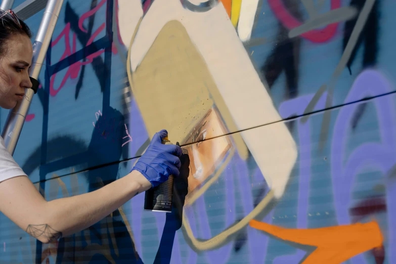 a woman is painting a mural on the side of a building, an airbrush painting, unsplash, graffiti, thumbnail, hyperdetailed, gold paint, maintenance photo