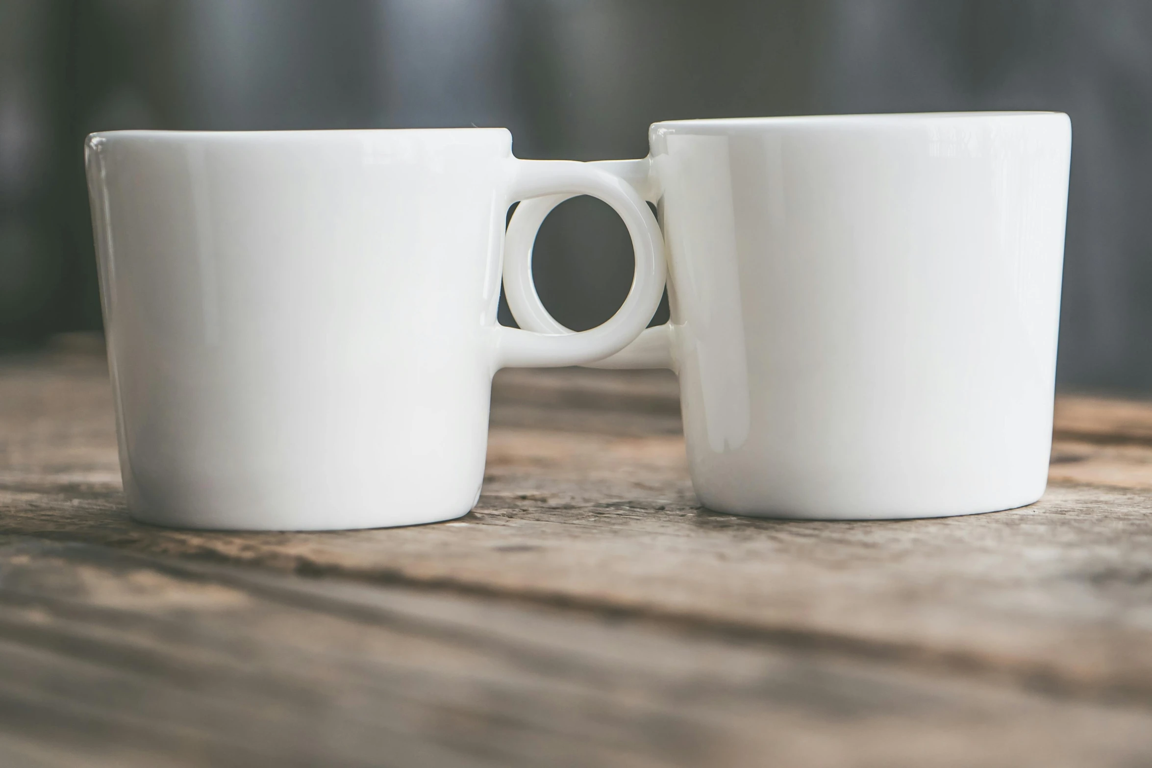 two white coffee cups sitting on top of a wooden table, inspired by Cerith Wyn Evans, unsplash, minimalism, square, mug shot, circle, close up front view