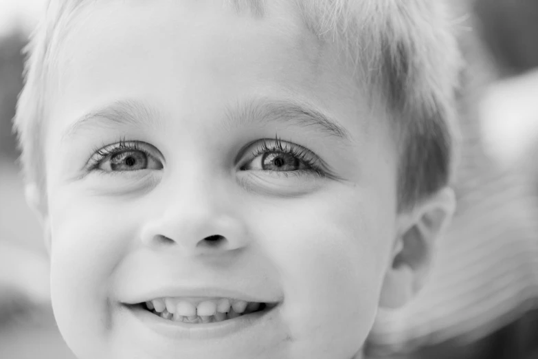 a black and white photo of a young boy, a black and white photo, pexels contest winner, large happy eyes, closeup of an adorable, cavities, smiling in heaven