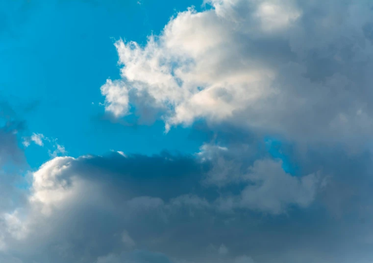 a plane flying through a cloudy blue sky, by Jan Rustem, unsplash, minimalism, colorful dramatic puffy clouds, color ( sony a 7 r iv, low angle 8k hd nature photo, extra high resolution