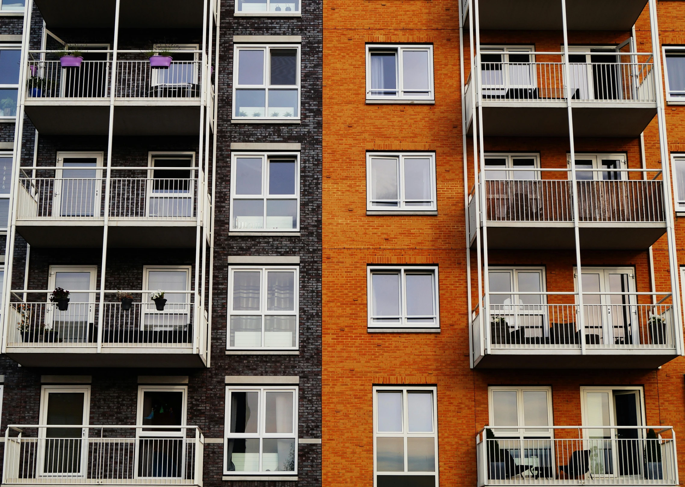 an apartment building with balconies and balconies on the balconies, by Carey Morris, pexels contest winner, orange grey white, flat, three quarter view, frontal picture