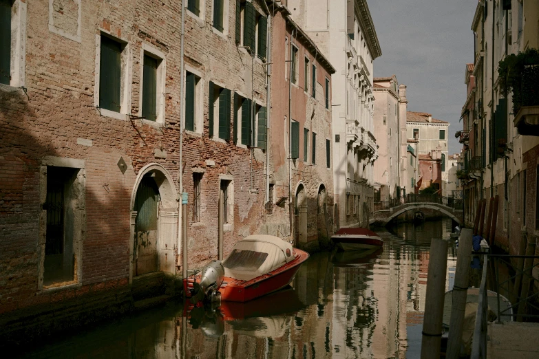 a boat that is sitting in the water, by Canaletto, pexels contest winner, shady alleys, medium format. soft light, payne's grey and venetian red, ignant