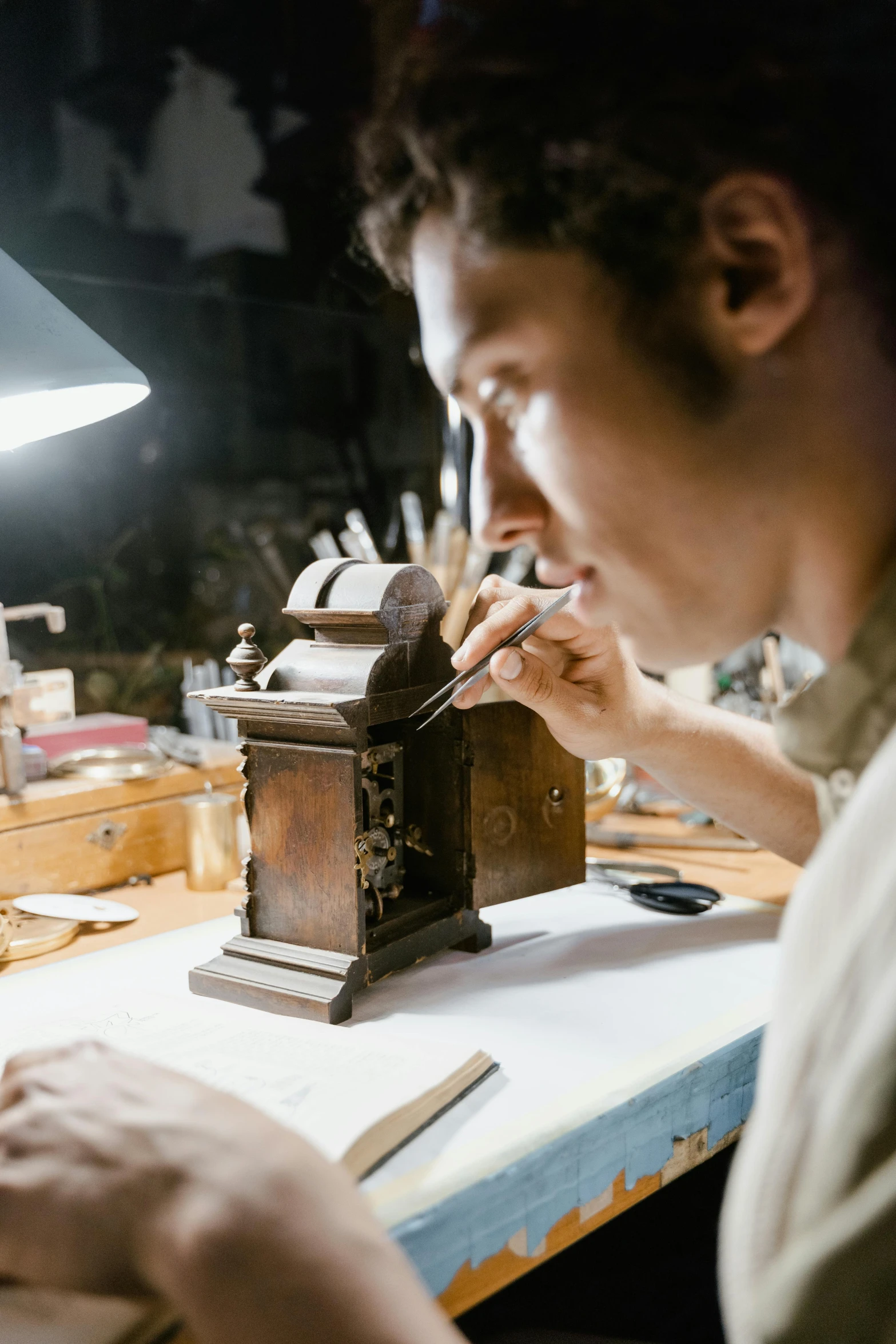 a man sitting at a table working on a piece of wood, pexels contest winner, arts and crafts movement, mechanical clock, looking at the treasure box, profile picture, cinematic still