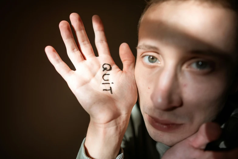 a close up of a person holding a hand with a number on it, inspired by Claude Cahun, trending on pexels, graffiti, cute young man, portrait of depressed teen, cut out, ocult
