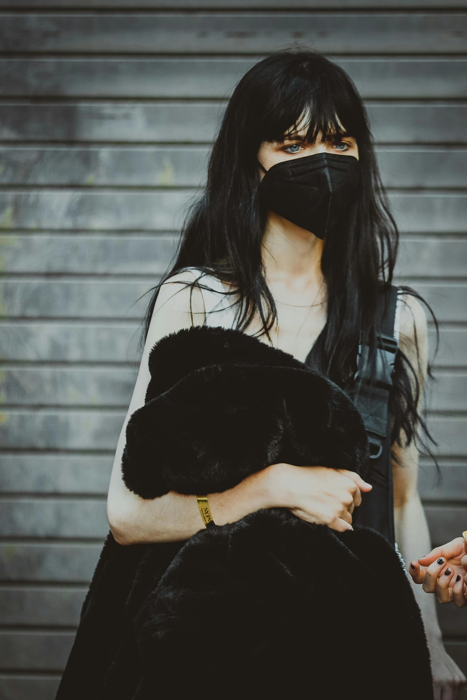 a woman in a black dress and a black mask, inspired by Elsa Bleda, reddit, visual art, resembling a mix of grimes, long black hair with bangs, photograph taken in 2 0 2 0, synthetic fur