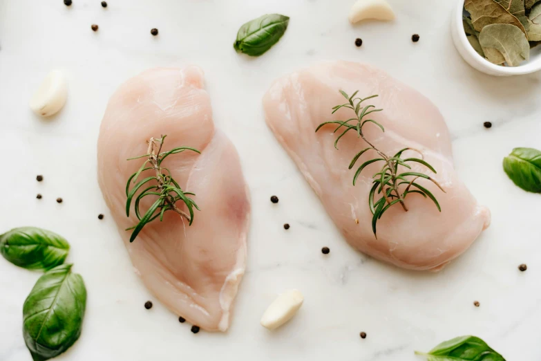 two raw chicken breasts with herbs and garlic, trending on pexels, renaissance, smooth marble surfaces, 6 pack, cut out, handcrafted