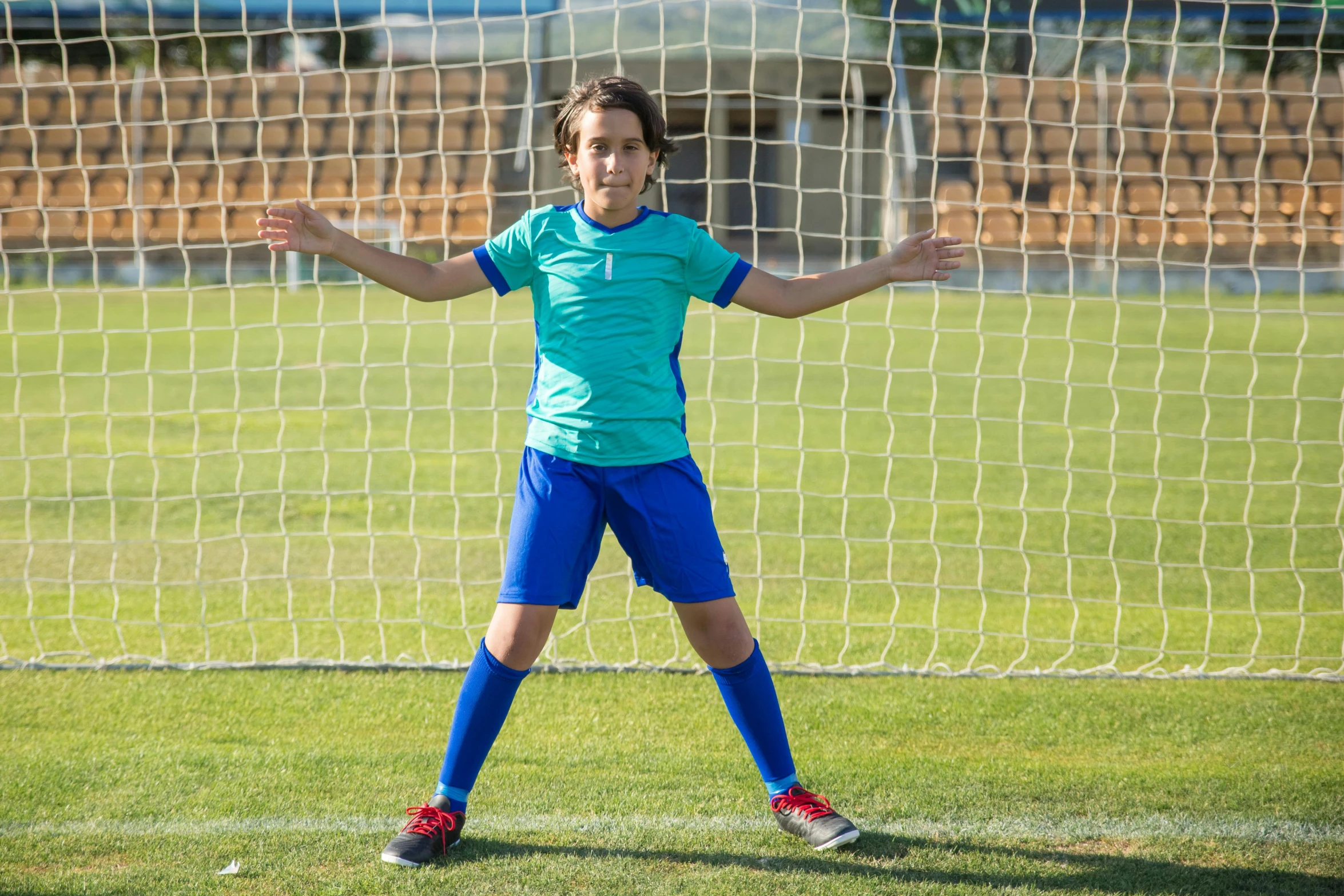 a woman standing in front of a soccer goal, shutterstock contest winner, happening, 14 yo berber boy, his arms spread. ready to fly, 15081959 21121991 01012000 4k, nice face