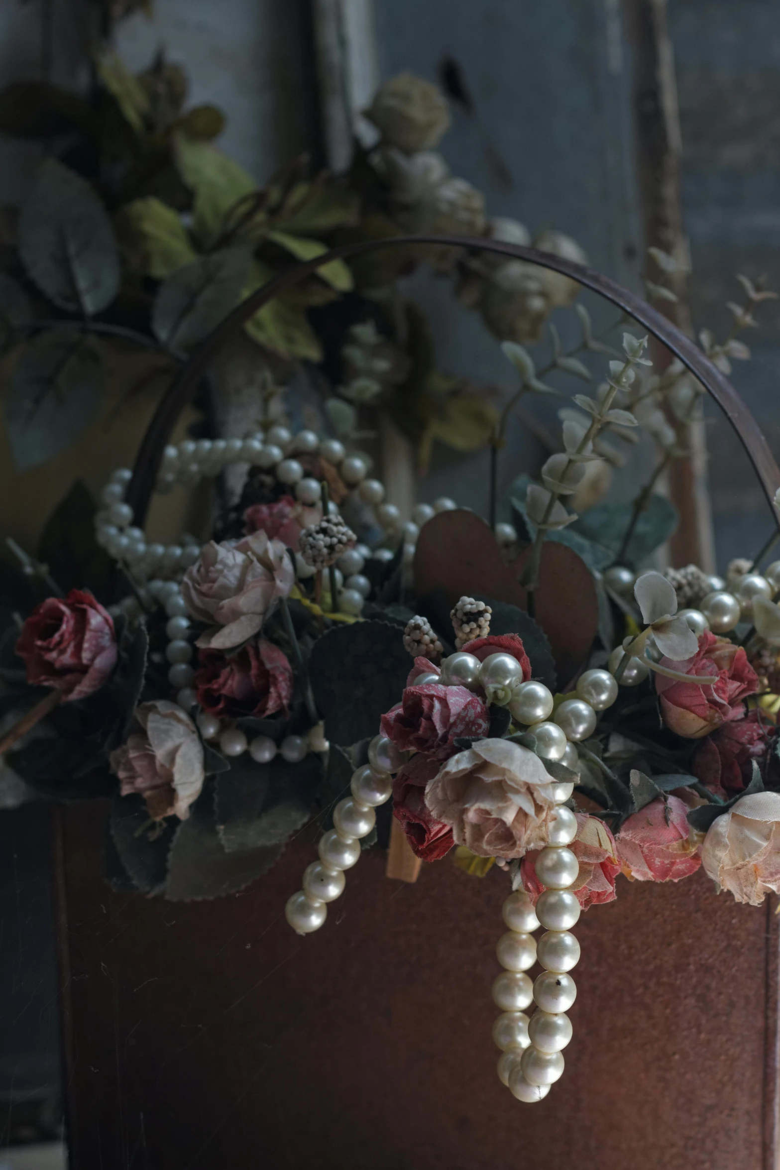 a basket filled with flowers sitting on top of a table, inspired by Jacopo Bassano, unsplash, baroque, pearls and chains, soft dark muted colors, detail shot, victorian photograph