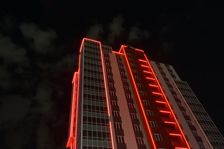 a tall building lit up with red lights, volumetric neon lighting, anton fadeev 8 k, low quality photo, avangard