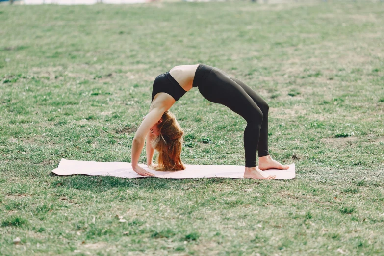 a woman doing a yoga pose in a park, by Emma Andijewska, arabesque, arched back, no cropping, profile image, instagram picture